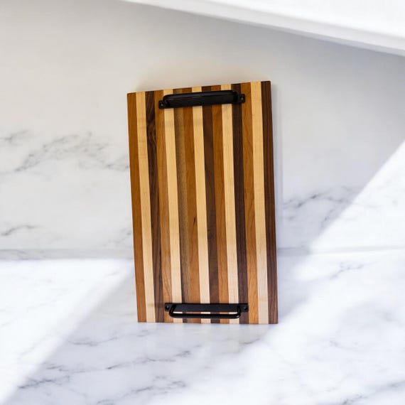 A tricolor walnut/cherry/maple end-grain or edge-grain board where the wood itself does all the decorating — no laser branding needed.