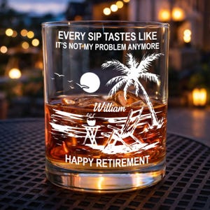 Könnte beinhalten: Ein klares Whiskyglas gefüllt mit einer braunen Flüssigkeit und Eis. Das Glas zeigt eine weiße Grafik einer Strandszene mit einer Palme, Sonne und Text, der lautet: "EVERY SIP TASTES LIKE IT'S NOT-MY PROBLEM ANYMORE" und "HAPPY RETIREMENT".