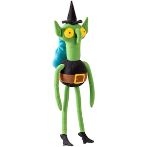 Pode incluir: Uma boneca de pelúcia verde com pescoço longo, orelhas pontudas e olhos amarelos grandes. Usa um chapéu pontudo preto, um torso redondo preto com um cinto marrom com fivela amarela e pés pretos. Uma mecha de cabelo azul sai da parte de trás da cabeça.