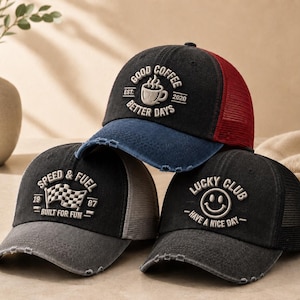 Puede incluir: Tres gorras de camionero desgastadas con diseños bordados. Una gorra dice "GOOD COFFEE BETTER DAYS" con un gráfico de taza de café. Otra dice "SPEED & FUEL" con una bandera a cuadros. La tercera gorra dice "LUCKY CLUB" con una carita sonriente.