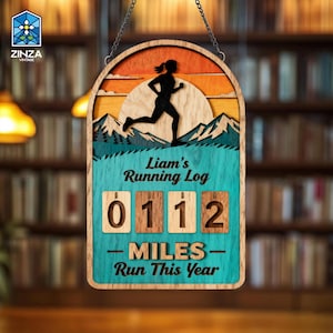 May include: Wooden running log sign featuring a runner silhouette, mountains, and a sunset design. The sign says "Liam's Running Log" and "0112 Miles Run This Year". The sign is suspended by a chain.