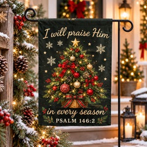 Pode incluir: Uma bandeira de jardim retangular preta com uma árvore de Natal decorada num cesto, estrelas douradas e flocos de neve brancos. O texto diz: I will praise Him in every season PSALM 146:2. O design inclui laços e enfeites vermelhos.