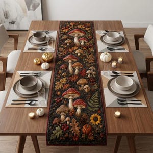 Puede incluir: Un camino de mesa rectangular con fondo oscuro y un patrón detallado de varios hongos, hojas de otoño, girasoles y bayas. El camino está centrado en una mesa de comedor de madera con cuencos, platos y pequeñas calabazas blancas.