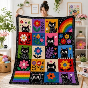 May include: A quilted throw blanket featuring a grid of colourful squares with illustrations of black cats, various flowers, and rainbows. The quilt has a black border with white dots and is constructed with visible stitching throughout the fabric.