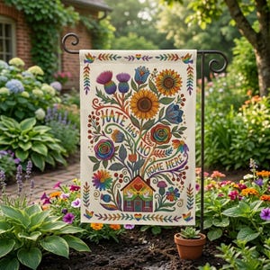 May include: A garden flag with a floral design and the words "Hate Has No Home Here." The flag features colorful flowers, including sunflowers, roses, and thistles, with a rainbow-colored house at the bottom. The flag is displayed on a black metal stand.