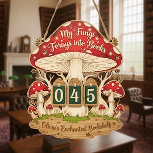 May include: Wooden mushroom-shaped sign with the text "My Fungi Forays into Books" in red and white. The sign has a counter displaying "045" and the text "Olivia's Enchanted Bookshelf". The sign is decorated with red and white mushrooms.