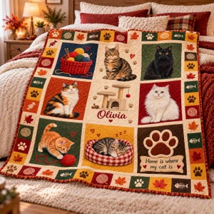 May include: A patchwork quilt featuring various cat illustrations, a cat tree, and yarn balls. The text reads Olivia and Home is where my cat is. The design includes autumn leaves, paw prints, and fish bones in a grid pattern with red, green, and yellow squares.