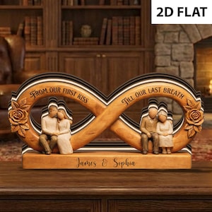 Puede incluir: Escultura de signo infinito de madera con figuras talladas de parejas y rosas. El letrero tiene las frases "From our first kiss" y "Till our last breath". Los nombres "James & Sophia" están grabados en la base.