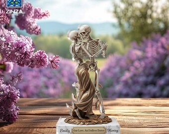 May include: A decorative figurine of two skeletons embracing, with one skeleton wearing a draped garment. The base is inscribed with "Emily Our Love, An Endless Dance Henry". The background features purple flowers and a blurred outdoor scene.