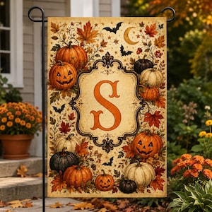 May include: A rectangular garden flag featuring a central ornate frame with the letter S in orange. The design includes various pumpkins, some with carved jack-o'-lantern faces, surrounded by autumn leaves, stars, a crescent moon, and bats.