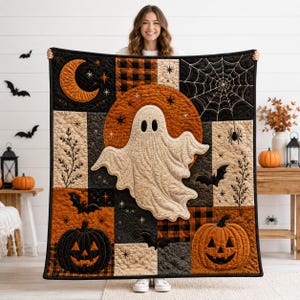 May include: A rectangular quilt featuring a central cream-colored ghost against a large orange moon. The design includes black and orange buffalo plaid, spiderwebs, bats, and jack-o'-lanterns in a patchwork layout with black borders.