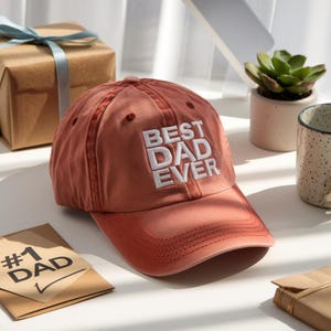 May include: A red baseball cap with the words "Best Dad Ever" embroidered in white on the front.