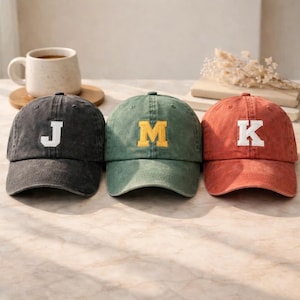 Könnte beinhalten: Eine weiße Keramik-Tasse mit schwarzem Henkel und dem Text "But first, coffee" in handschriftlichem Stil. Die Tasse steht auf einer weißen Oberfläche. Die Tasse ist etwa 10 cm hoch.