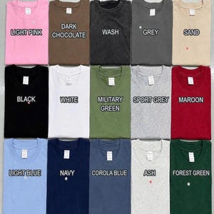 May include: A T-shirt color chart displaying fifteen folded crew neck shirts in various colors including light pink, dark chocolate, wash, grey, sand, black, white, military green, sport grey, maroon, light blue, navy, corola blue, ash, and forest green.
