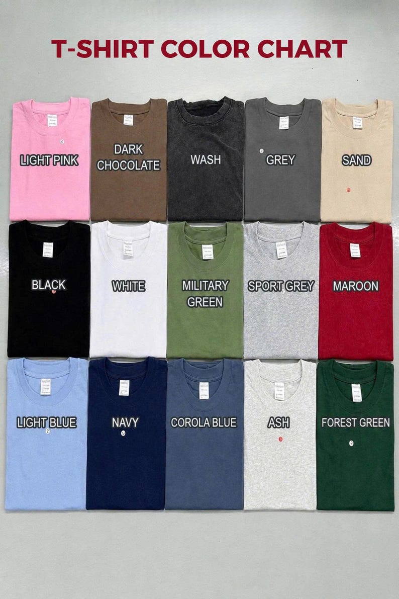 May include: A T-shirt color chart displaying fifteen folded crew neck shirts in various colors including light pink, dark chocolate, wash, grey, sand, black, white, military green, sport grey, maroon, light blue, navy, corola blue, ash, and forest green.