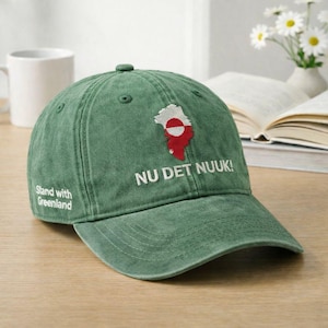 May include: Green baseball cap with the text "NU DET NUUK!" and a map of Greenland in red and white. The phrase "Stand with Greenland" is printed on the side of the cap.