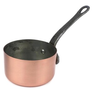 May include: A copper saucepan with a dark, textured handle. The pan has a rounded base and a shiny surface. The handle is attached to the side and has a loop for hanging. The pan is suitable for cooking.