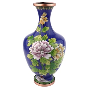 May include: A blue cloisonné vase with a copper rim and base. The vase features a floral design with pink and yellow peonies and green leaves. The vase has a bulbous body and a narrow neck.