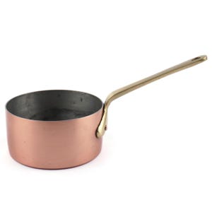 May include: A round copper saucepan with a metallic interior and a long, slender brass handle attached to the side with a single rivet. The exterior of the pan features a smooth, polished copper finish, while the handle has a golden tone.