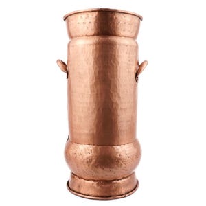 May include: A hammered copper umbrella stand with two handles. The stand is tall and cylindrical with a rounded base.