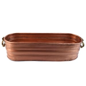 Puede incluir: Una bañera de metal de color cobre, de forma ovalada, con dos asas de latón. La bañera tiene un diseño acanalado alrededor del exterior. La bañera está vacía y se encuentra sobre un fondo blanco. La bañera mide unos 51 cm de largo.