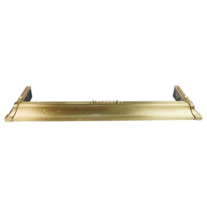Puede incluir: Un guardafuegos dorado con detalles decorativos. El guardafuegos tiene forma rectangular con adornos en los extremos y un diseño central en forma de cadena. El diseño general es clásico y elegante.