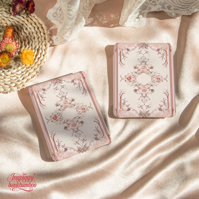Puede incluir: Dos cajas rectangulares rosas y crema con dise&ntilde;os florales. Las cajas tienen un borde rosa y un centro crema con un arreglo floral. Est&aacute;n sobre una superficie satinada. El texto "Ingpiggy bankbamboo" es visible.