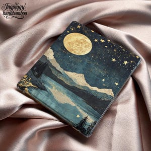 May include: A rectangular protective case featuring a dark blue night sky with a large golden moon and scattered stars above a landscape of mountains, a lake, and pine trees. The text Ingpiggy bankbamboo is printed in the top left corner.