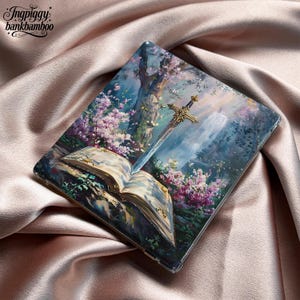 May include: A clear phone case featuring a fantasy scene with a sword, an open book, and a waterfall. The artwork includes pink and purple flowers, a large tree, and a golden hilt on the sword. The case is on a satin surface.