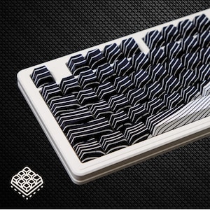 May include: A mechanical keyboard featuring a white frame and custom keycaps with a dark navy blue and white striped pattern. The keys are arranged in a standard layout, with a prominent white spacebar featuring diagonal black stripes.
