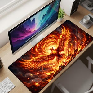 May include: A rectangular desk mat with a striking phoenix design. The artwork depicts a fiery phoenix in shades of orange, red, and yellow, set against a dark backdrop. The mat is designed to protect the desk surface, measuring approximately 80 cm in length.