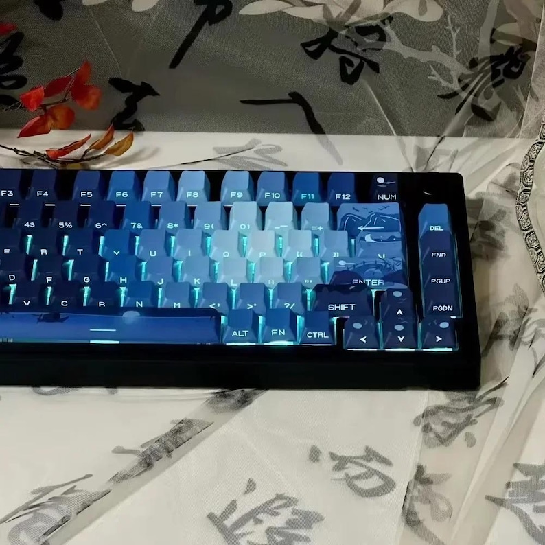 May include: A blue and black mechanical keyboard with a gradient color scheme on the keys. The keyboard has a number pad, function keys, and arrow keys. The keys are backlit with a blue light.