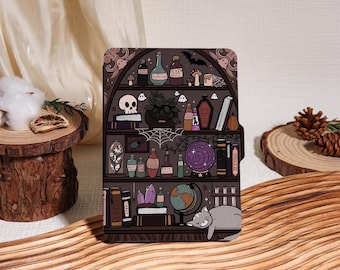 Könnte beinhalten: Eine dekorative Tablet-Hülle mit einer skurrilen Illustration eines Hexenregals. Das Design umfasst Zaubertränke, einen Totenkopf, eine Kristallkugel und eine schlafende graue Katze. Die Farbpalette ist hauptsächlich Dunkelviolett, Braun und Grau.