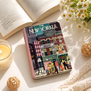 May include: A rectangular metal tin featuring a vintage New Yorker magazine cover illustration from June 1, 1946. The artwork depicts a detailed city street scene with brick buildings, storefronts, a horse-drawn cart, and various signs.