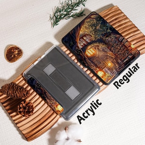 May include: Two tablet cases, one acrylic and one regular, are displayed on a wooden surface. The regular case features a detailed illustration of a building with warm lighting. The acrylic case is gray with a stand. The word "Acrylic" and "Regular" are printed on the cases.