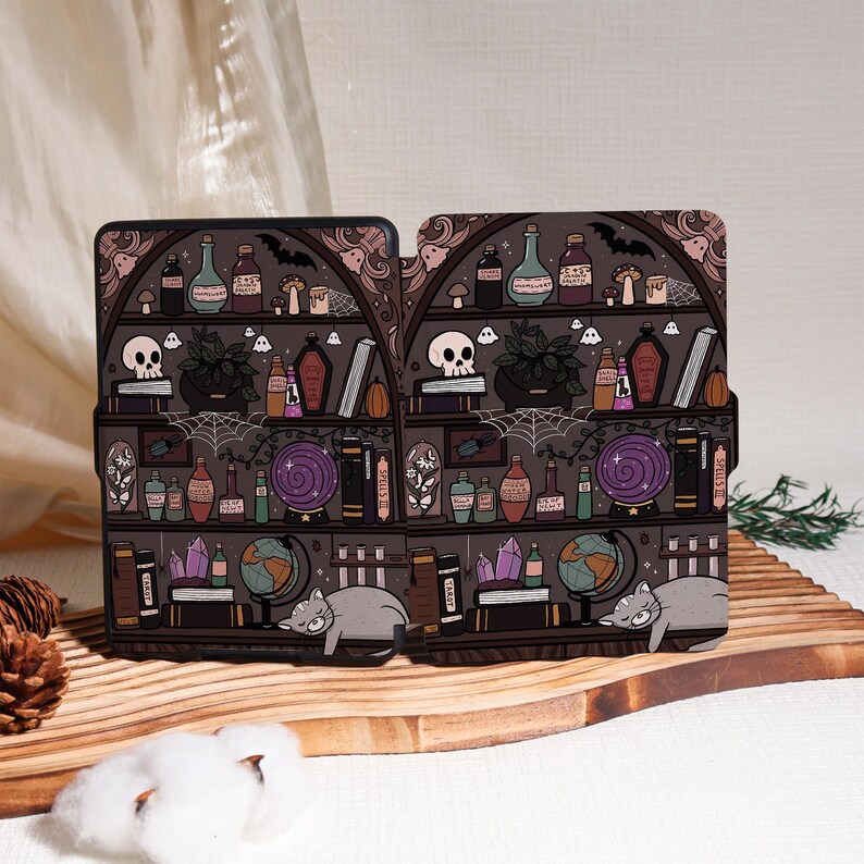 May include: Two-piece phone case featuring a whimsical witchy bookshelf design. The dark brown shelves are filled with potion bottles, books, a skull, and a sleeping gray cat. The case has a decorative, gothic-inspired arch.