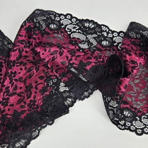 Op de afbeelding: Zwarte en roze kantbies met een bloemenpatroon.