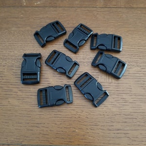 May include: Eight black plastic side release buckles. The buckles are approximately 2.5 cm long and have a smooth, matt finish.