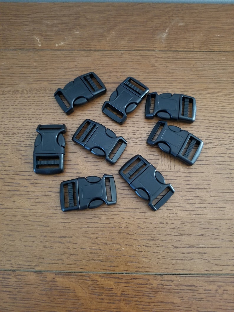 May include: Eight black plastic side release buckles. The buckles are approximately 2.5 cm long and have a smooth, matt finish.