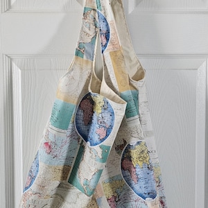 May include: A reusable tote bag made of natural fabric with a map of the world print. The bag features a blue, green, and yellow color scheme with a vintage aesthetic.