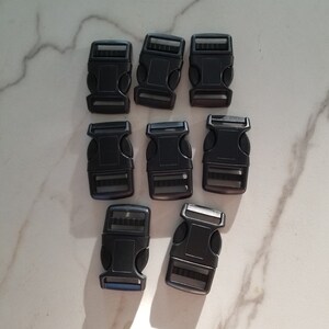 May include: Eight black plastic side release buckles. The buckles are approximately 2.5 cm long and 1.5 cm wide.