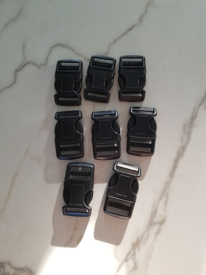 May include: Eight black plastic side release buckles. The buckles are approximately 2.5 cm long and 1.5 cm wide.