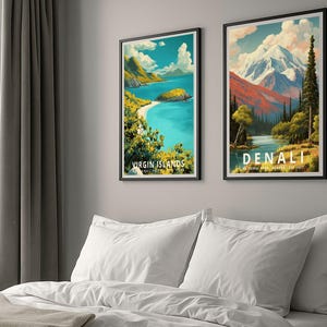 K&ouml;nnte beinhalten: Zwei gerahmte Reiseplakate, eines mit "VIRGIN ISLANDS" und das andere mit "DENALI NATIONAL PARK ALASKA EST. 1917". Die in Schwarz gerahmten Poster zeigen malerische Landschaften in leuchtenden Farben, die &uuml;ber einem Bett mit wei&szlig;er Bettw&auml;sche h&auml;ngen.
