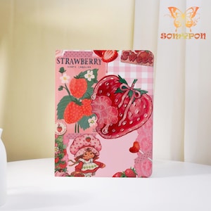 May include: A pink and red strawberry-themed notebook with a vintage illustration. The cover features a large strawberry, the text "Strawberry North Carolina", and a cartoon character. The design includes a gingham pattern and the word "Sweet".