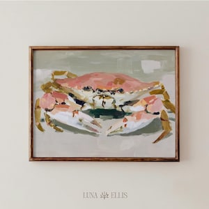 May include: A framed painting of a crab. The crab is painted in shades of pink, white, and gold, with a green background. The painting is in a wooden frame. The artist's name, LUNA ELLIS, is at the bottom.