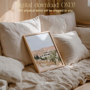 May include: A framed landscape art print featuring a desert scene with mountains, trees, and a blue sky. The artwork is in a light wooden frame. The text "Digital download ONLY! NO physical items will be shipped to you" is at the top.