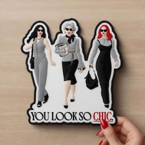 May include: A die-cut sticker depicting three stylish figures in monochrome outfits, each wearing sunglasses. The figures are in shades of grey and black, with red accents. The text "YOU LOOK SO CHIC" is at the bottom.