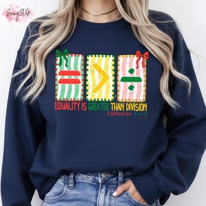 May include: Navy blue sweatshirt with the text "Equality is Greater Than Division" and the Bible verse Ephesians 2:4-8. The design features colourful mathematical symbols in gift box-like frames.