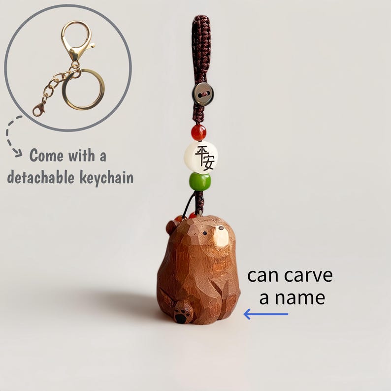 May include: A brown wooden bear keychain with a detachable gold-colored keychain. The bear has a carved design and is attached to a cord with beads. The text "can carve a name" is visible.