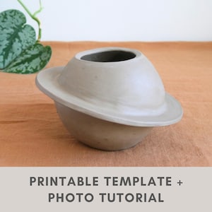 May include: A light gray ceramic bowl with a wide, flat, circular rim extending from the center, resembling the shape of a planet with rings. The text PRINTABLE TEMPLATE + PHOTO TUTORIAL is displayed at the bottom of the image.
